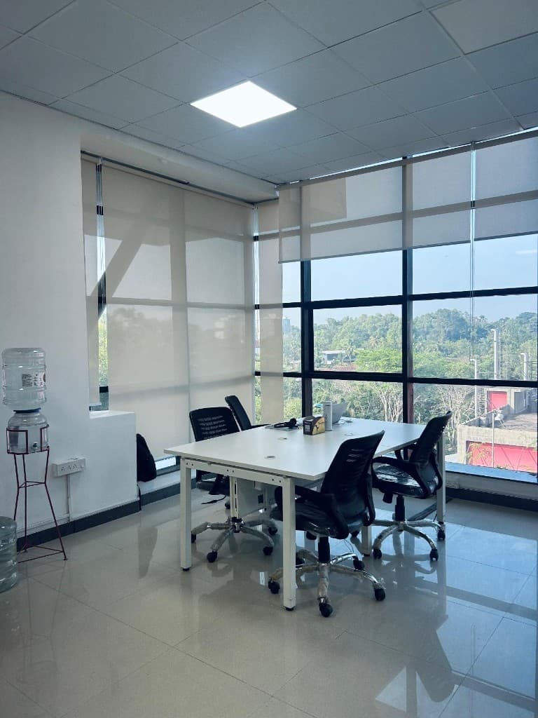 Meeting area with chairs and a laptop by the office windows
